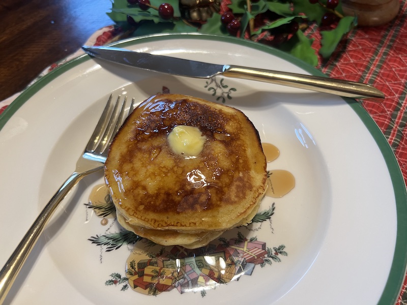 eggnog pancakes on a plate with butter and maple syrup